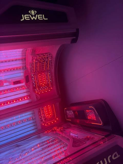 Interior of a red light therapy bed with red and purple illumination